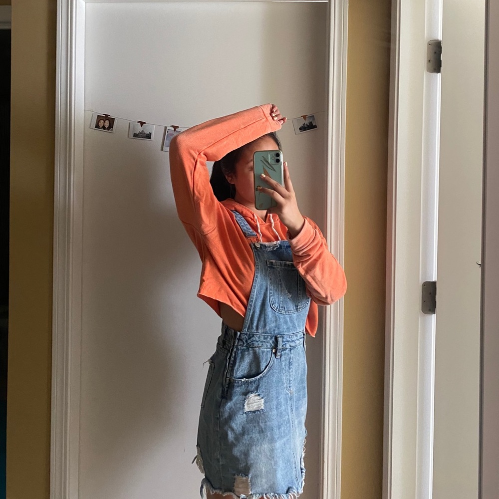 Denim distressed skirt overalls with pockets.